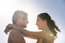 Happy young couple embracing against clear sky — Stock Photo
