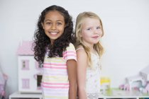 Портрет улыбающихся маленьких девочек, стоящих вместе — стоковое фото