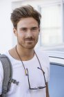 Portrait of happy young man standing in front of car — Stock Photo