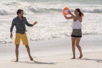 Joyeux jeune couple jouant au beach ball — Photo de stock