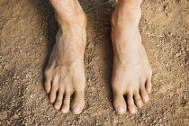 Крупним планом чоловічі ноги, що стоять на землі — стокове фото