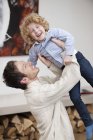 Fröhlicher Mann spielt zu Hause mit Sohn — Stockfoto