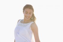 Smiling young woman standing on white background — Stock Photo