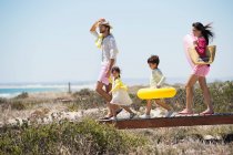 Family walking on a boardwalk on the beach — Stock Photo
