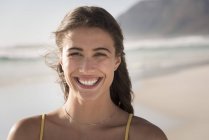 Портрет молодої усміхненої жінки на пляжі — стокове фото