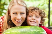 Mutter und Sohn lehnen an Wassermelone — Stockfoto