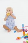 Blonder Babyjunge trinkt Saft aus Babyflasche auf weißem Hintergrund — Stockfoto