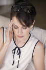 Nahaufnahme einer Frau mit geschlossenen Augen, die unter Kopfschmerzen leidet — Stockfoto