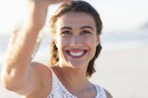 Щаслива молода жінка бере селфі на пляжі — стокове фото