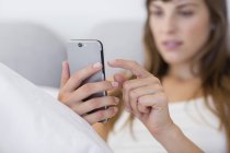 Крупным планом сообщения молодой женщины с мобильного телефона — стоковое фото