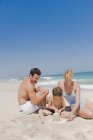 Família fazendo castelo de areia na praia — Fotografia de Stock