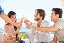 Group of friends toasting with drinks outdoors on vacation — Stock Photo