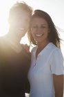 Nahaufnahme eines lächelnden Paares, das zusammen im Sonnenlicht steht — Stockfoto
