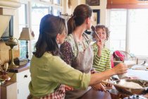 Multi generation family cooking food at kitchen — Stock Photo