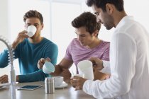 Nahaufnahme von drei Freunden beim Kaffeetrinken in der Küche — Stockfoto