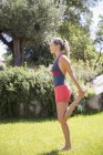 Donna in piedi su una gamba mentre si esercita in giardino — Foto stock