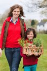 Mother and son with a crate of homegrown vegetables — Stock Photo