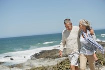 Romantique couple aîné marche sur la plage — Photo de stock
