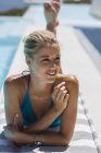 Gros plan de la jeune femme blonde se relaxant au bord de la piscine — Photo de stock