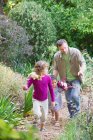 Отец с двумя детьми, гуляющими в саду — стоковое фото