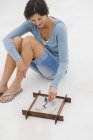 Улыбающаяся женщина играет с песочницей на полу — стоковое фото