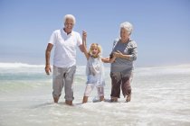 Дівчина розважається на морському пляжі з бабусею і дідусем — стокове фото
