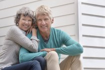 Портрет счастливой пожилой пары, сидящей вне дома — стоковое фото