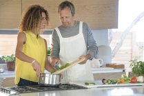 Couple heureux préparant la nourriture dans la cuisine ensemble — Photo de stock