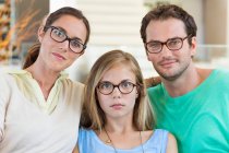 Retrato de uma família sentada em um sofá e usando óculos — Fotografia de Stock