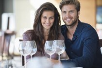 Retrato de casal feliz desfrutando de vinho branco no restaurante — Fotografia de Stock
