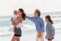Heureuse famille multi-générations appréciant sur la plage — Photo de stock