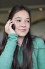 Nahaufnahme eines Mädchens, das mit dem Handy spricht und wegschaut — Stockfoto