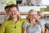 Children covering parents eyes — Stock Photo