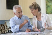 Konzentriertes Senioren-Paar sortiert Rechnungen zu Hause am Tisch — Stockfoto
