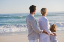 Семья, стоящая на пляже — стоковое фото