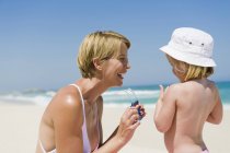 Donna che si diverte con figlia sulla spiaggia — Foto stock