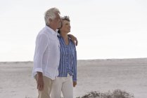 Heureux couple de personnes âgées marchant sur la plage ensemble — Photo de stock