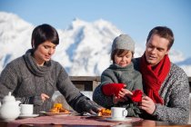 Paar und Tochter essen auf Balkon im Skigebiet — Stockfoto