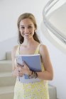 Щаслива студентка-підліток тримає книги на сходах — стокове фото
