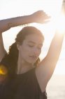 Sinnliche junge Frau posiert am Strand im Sonnenlicht — Stockfoto