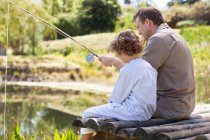 Padre e hijo pescando en un lago - foto de stock