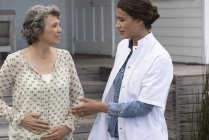 Щаслива медсестра, яка допомагає старшій жінці в будинку престарілих — стокове фото