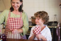 Großmutter und kleiner Junge kochen Essen in der Küche — Stockfoto