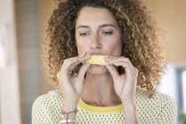 Close-up of woman eating slice of fresh pineapple — Stock Photo