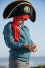 Pirata niño sosteniendo monedas al aire libre - foto de stock