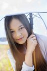 Portrait of happy teenage girl holding umbrella outdoors — Stock Photo