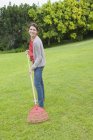 Portrait of smiling woman raking green lawn — Stock Photo