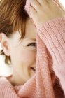 Portrait of young woman with short hair covering face with jumper — Stock Photo