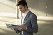Eleganter junger Geschäftsmann liest Zeitschrift — Stockfoto