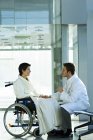 Чоловік лікар втішає інваліда жінки-пацієнта в лікарні — стокове фото